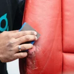 Mano lijando suavemente una superficie de cuero reparado con relleno especializado