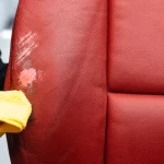 Persona limpiando cuidadosamente el compuesto de relleno de cuero con herramienta y paño de microfibra